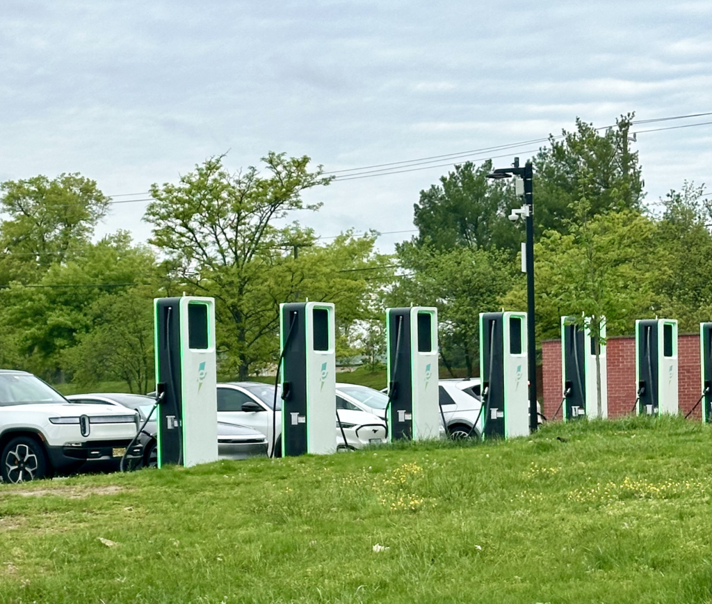 Eight public EV Charging stations at commercial location with EVs plugged in.